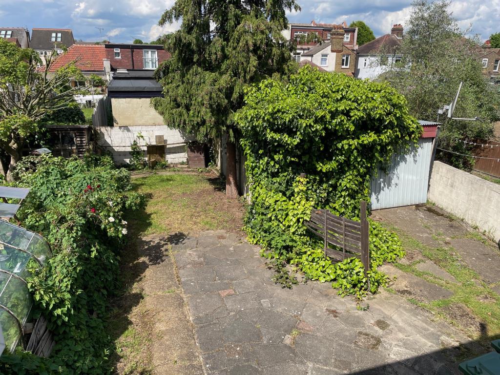 Lot: 178 - SEMI-DETACHED HOUSE FOR IMPROVEMENT - View from first floor of the paved patio leading to lawn and access to garage
